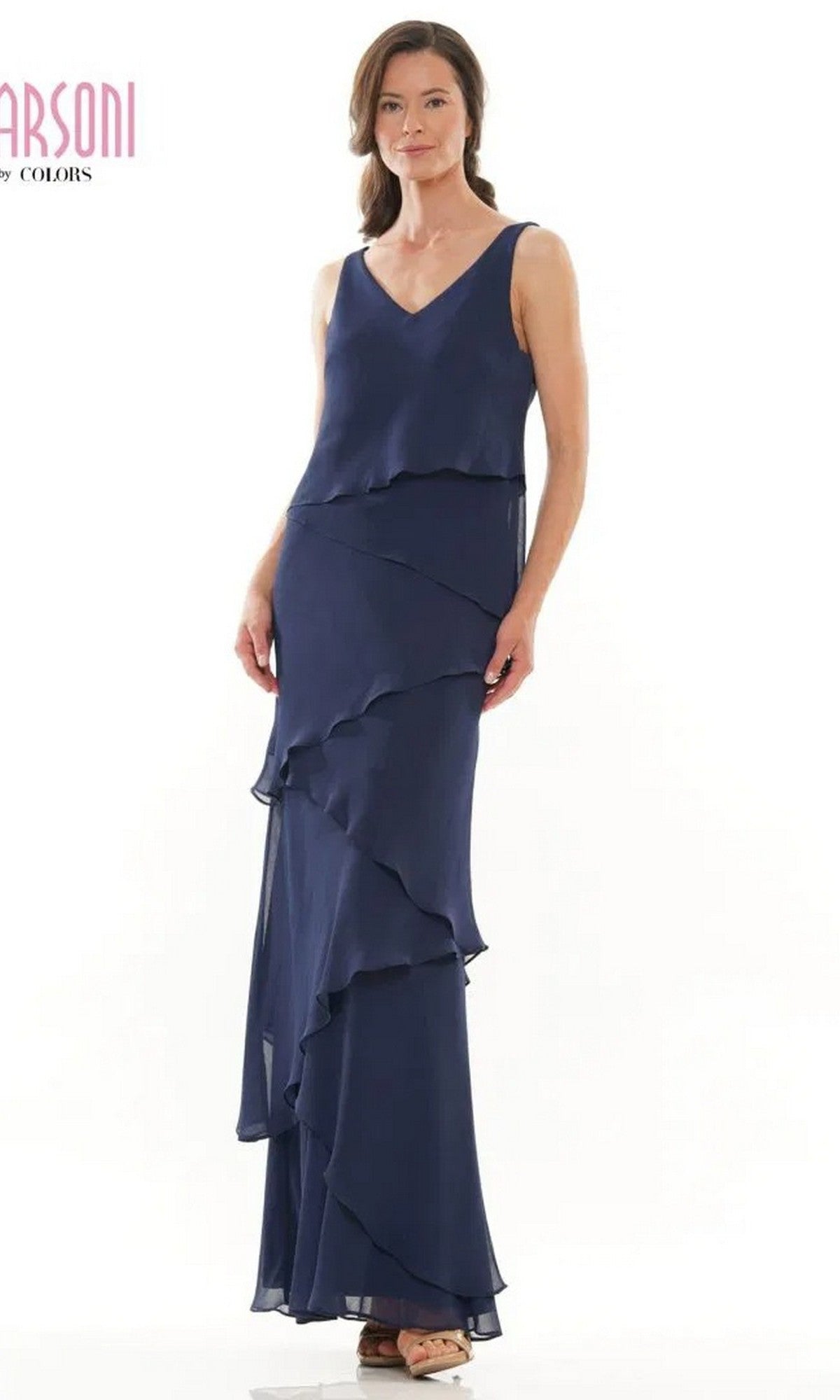 A woman in a sleeveless, navy blue Marsoni M309 long formal dress with asymmetrical chiffon ruffles stands against a white background.